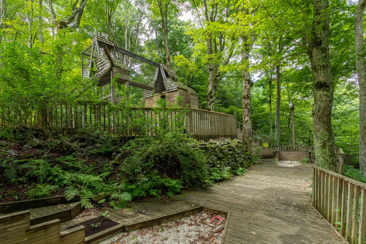 This exterior image shows a peaceful wooden structure nestled among greenery with a winding pathway. The setting captures the tranquility of nature and invites exploration of the surrounding area.