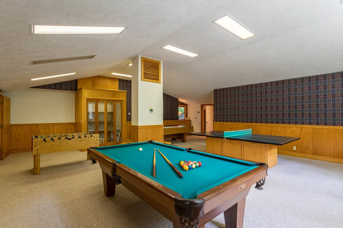 This inviting patio area features a hot tub surrounded by trees. The space offers opportunities for relaxation, socializing, and enjoying the tranquility of nature, making it an ideal spot for winding down after group festivities.